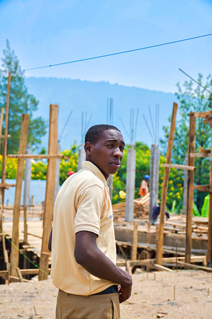 about-01 Young man at a construction site with mountain background in Rwanda.