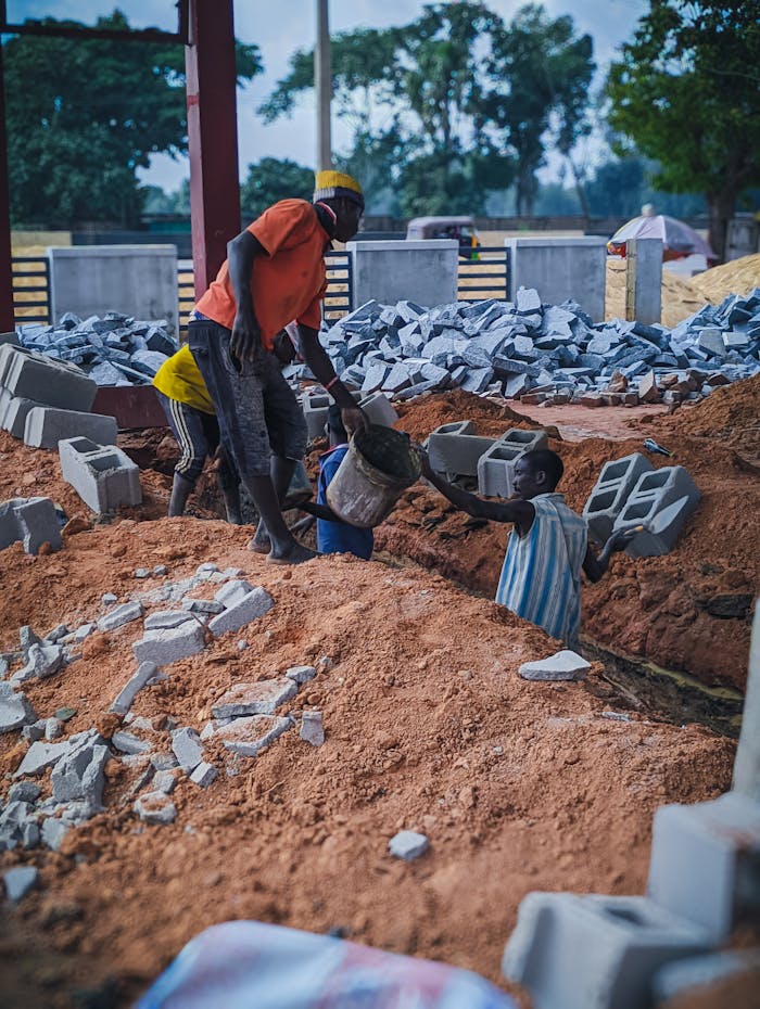 hero-img-02 Local workers at a construction site handling bricks and materials in Kaduna, Nigeria.